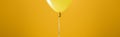 Festive bright minimalistic decorative balloon on yellow background, panoramic shot.