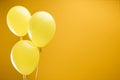 Festive bright minimalistic decorative balloons on yellow background with copy space.