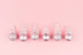 Festive bright new year background - glitter silver balls in row as decorative border on soft light pastel pink background. Royalty Free Stock Photo