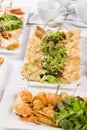 Festive Buffet. An assortment of cold snacks on wooden skewers. Decorated with lettuce leaves and served on rectangular Royalty Free Stock Photo