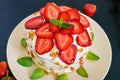 A festive cake with fresh strawberries, cream, decorated with mint leaves on a black background. Royalty Free Stock Photo