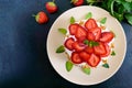 A festive cake with fresh strawberries, cream, decorated with mint leaves on a black background Royalty Free Stock Photo