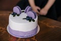 A festive cake in lilac style decorated with cakes, macaroni cookies with filling, fruits and berries on the cake