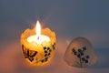 Festive candle burning in a candlestick made of glass. Festive painted egg Royalty Free Stock Photo