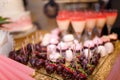 festive candy bar with cupcakes, macarons, coctail glasses and strawberries in chocolate glaze. Unfocused pink cake on background. Royalty Free Stock Photo