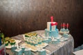 Festive candy bar for one year old boy birthday party. Cake with red number 1 and butterfly bow on shirt. Blue cakepops, cupcakes
