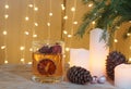 Festive card with candles and cones under a Christmas tree on a wooden table Royalty Free Stock Photo