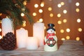 Festive card with festive garland, a snowman stands on a wooden table Royalty Free Stock Photo