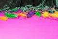 Festive carnival background, green velvet curtain colorful feather beads necklace for Mardi Gras Royalty Free Stock Photo