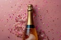 Festive Champagne Bottle with Golden Glitter Explosion Celebration on Pink Background Royalty Free Stock Photo