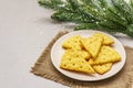 Festive cheese crackers, New Year snack concept. Cookies, fir tree branch, artificial snow, sackcloth napkin. Stone concrete Royalty Free Stock Photo