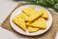 Festive cheese crackers, New Year snack concept. Cookies, fir tree branch, artificial snow, sackcloth napkin. Stone concrete