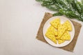 Festive cheese crackers, New Year snack concept. Cookies, fir tree branch, artificial snow, sackcloth napkin. Stone concrete Royalty Free Stock Photo