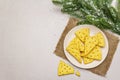 Festive cheese crackers, New Year snack concept. Cookies, fir tree branch, artificial snow, sackcloth napkin. Stone concrete Royalty Free Stock Photo