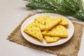 Festive cheese crackers, New Year snack concept. Cookies, fir tree branch, artificial snow, sackcloth napkin. Stone concrete