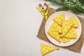 Festive cheese crackers, New Year snack concept. Cookies, mouse figure, fir tree branch, artificial snow, sackcloth napkin. Stone Royalty Free Stock Photo
