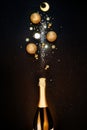 Festive Christmas background. Bottle of champagne with a spray of sparkles and Christmas decorations. Royalty Free Stock Photo