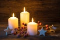 Festive Christmas background with burning candles, stars and red berries decoration. Royalty Free Stock Photo