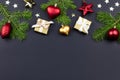 Festive Christmas background with fir branches, giftboxes, red decorations on black, copy space Royalty Free Stock Photo