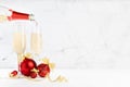 Festive christmas background with stream of pouring fizz champagne from bottle to two glasses, bright christmas decorations - red.