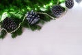 Festive Christmas border - green spruce branches decorated with pearls and pine cones, covered with snow, on a white Royalty Free Stock Photo