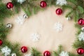 Festive christmas border with red and silver balls on fir branches and snowflakes on rustic beige background Royalty Free Stock Photo