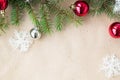 Festive christmas border with red and silver balls on fir branches and snowflakes on rustic beige background Royalty Free Stock Photo