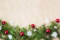 Festive christmas border with red and silver balls on fir branches and snowflakes on rustic beige background Royalty Free Stock Photo