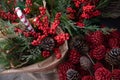 Festive Christmas bouquet of twigs of thuja, coniferous pine tree, ilex verticillata winterberries, decorated with cones