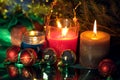 Festive christmas burning candles ubder the tree with gift box and baubles Royalty Free Stock Photo