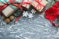 Festive Christmas composition with gifts, boxes, cones, walnuts, red flowers of poinsettia on a wooden background with white sprin Royalty Free Stock Photo