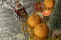 Festive Christmas composition. Tangerines, a statuette of Santa Claus and a Christmas tree are symbols of the holiday.