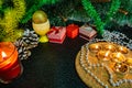 Festive Christmas composition with wax candles, gift boxes and silver beads. Decorations for new year`s eve. On a dark background Royalty Free Stock Photo