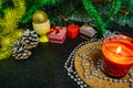 Festive Christmas composition with wax candles, gift boxes and silver beads. Decorations for new year`s eve. On a dark background Royalty Free Stock Photo