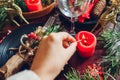 Festive Christmas dinner table setting for two decorated with fir branches, red candles, cones, ornaments. Royalty Free Stock Photo