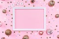 Festive christmas frame made of golden balls, fir tree branches, decorations and confetti on pastel pink background Royalty Free Stock Photo