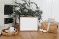 Festive Christmas home decor. Landscape wooden picture frame mockup on parquette floor. Pine, larch tree branches in Royalty Free Stock Photo