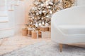Festive Christmas interior with decorated fir tree and white leather sofa in the foreground. Royalty Free Stock Photo
