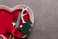 Festive Christmas Meal Background. Heart Shaped Plate With Knife And Fork And Christmas Antler And Tree Decorations