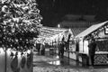 Festive Christmas and New Year's fair square in the city at night, falling snow, New Year tree and houses with garlands. Royalty Free Stock Photo