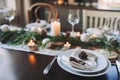 Festive Christmas and New Year table setting in scandinavian style with rustic handmade details in natural and white tones Royalty Free Stock Photo