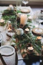 Festive Christmas and New Year table setting in scandinavian style with rustic handmade details in natural and white tones Royalty Free Stock Photo