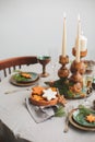 Festive Christmas and New Year table setting in scandinavian style with rustic handmade details in natural and white Royalty Free Stock Photo