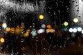 Blurred bokeh city light rainy windows  rain drops rainy street night people walking with umbrellas evening neon lantern reflectio Royalty Free Stock Photo