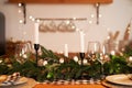 The festive Christmas table is decorated with branches of a Christmas tree, candles and garlands. Cozy home Christmas atmosphere Royalty Free Stock Photo