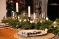 The festive Christmas table is decorated with branches of a Christmas tree, candles and garlands. Cozy home Christmas atmosphere Royalty Free Stock Photo