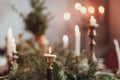 Festive Christmas table decoration arrangement with burning candles and fir branches Royalty Free Stock Photo