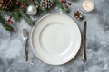 Festive Christmas Table Setting with Empty White Plate and Holiday Decorations Royalty Free Stock Photo