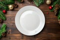Festive Christmas Table Setting with Empty White Plate and Holiday Decorations Royalty Free Stock Photo