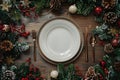 Festive Christmas Table Setting with Empty White Plate and Holiday Decorations Royalty Free Stock Photo